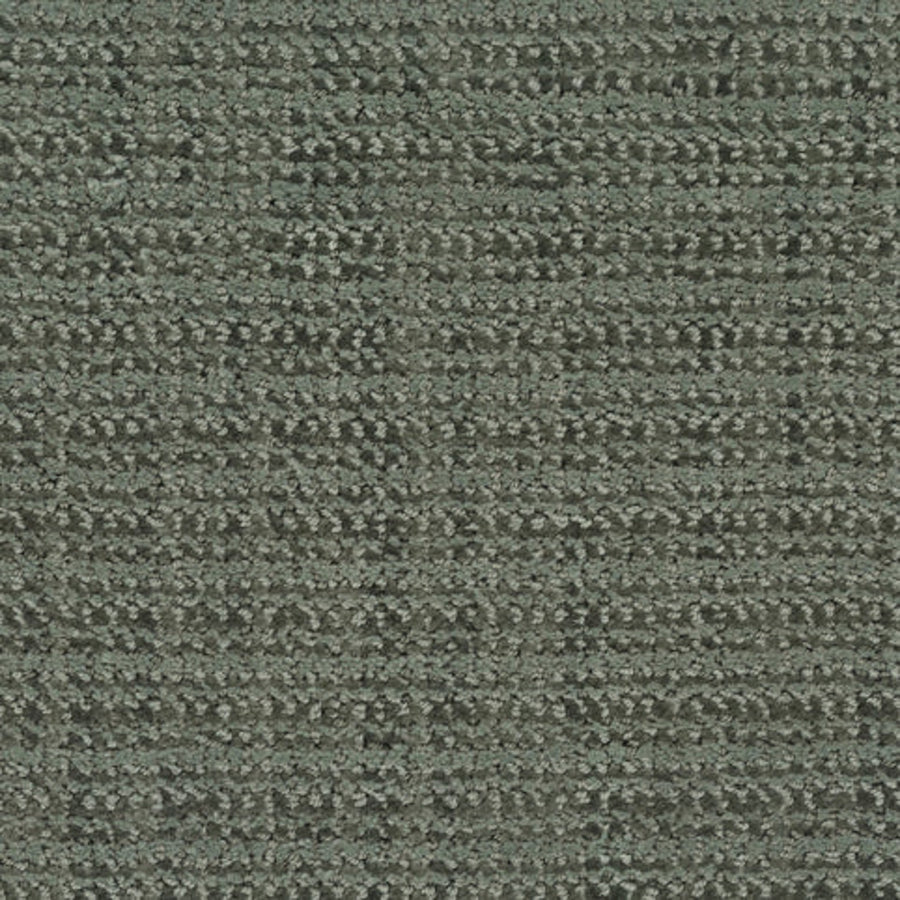 Close-up view of Beguiling Berber Carpet in Botanical color, showcasing its textured, looped style and subtle irregular grid pattern—a luxurious flooring choice with a modern touch.