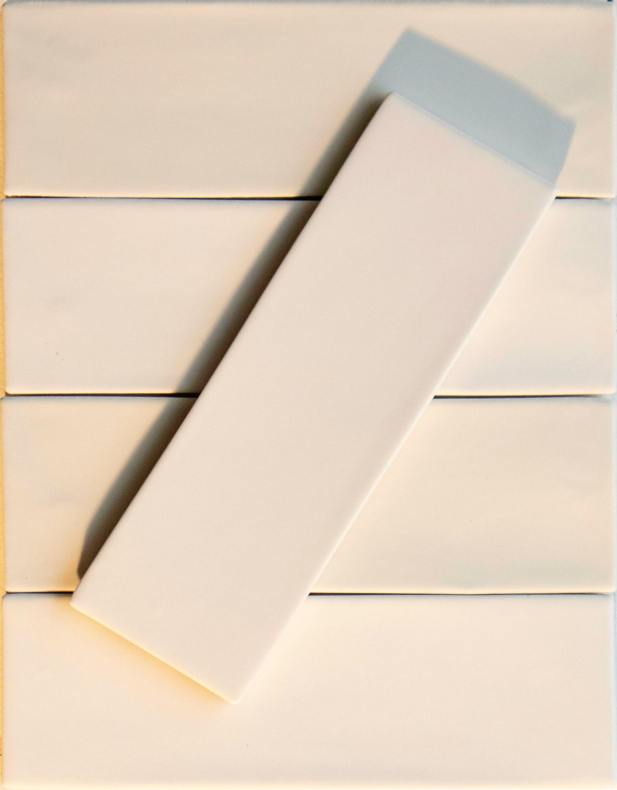 Six Noir Crackle 2.5x8 Ceramic Tiles in Bright Idea are arranged in two vertical columns, with one tile set diagonally across the others, creating a striking contrast of angles and shadows.