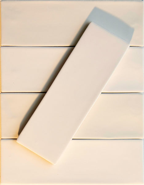 Six Noir Crackle 2.5x8 Ceramic Tiles in Bright Idea are arranged in two vertical columns, with one tile set diagonally across the others, creating a striking contrast of angles and shadows.