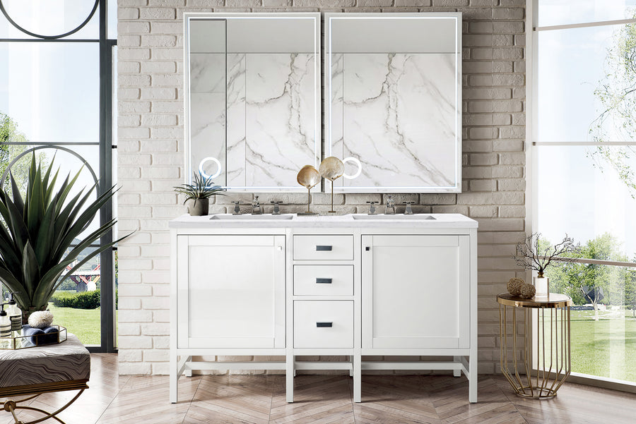 A modern white bathroom vanity with two sinks, two mirrors, marble backsplash, and decorative items on the countertop, set against a white brick wall with large windows and greenery outside.