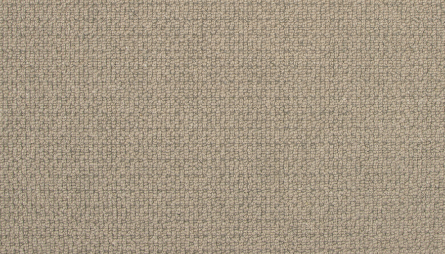 Close-up of Brixham Berber Carpet in Corduroy color—features a soft, tightly woven beige surface with a subtle textured grid pattern, offering durable style ideal for luxury home decor or upholstery projects.