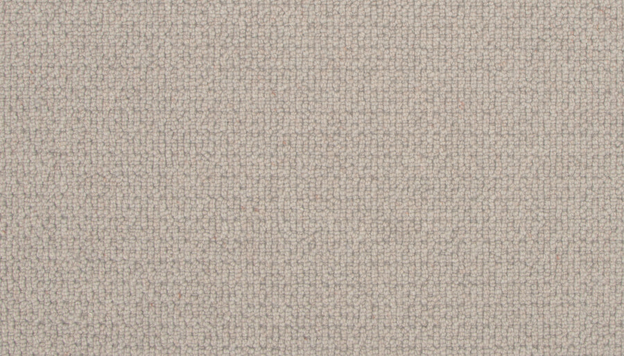 Close-up of the Brixham Berber Carpet in Canyon Fossil, featuring a light beige hue and woven grid-like texture. The soft, slightly rough surface displays visible threads that create a subtle, uniform patterned appearance.