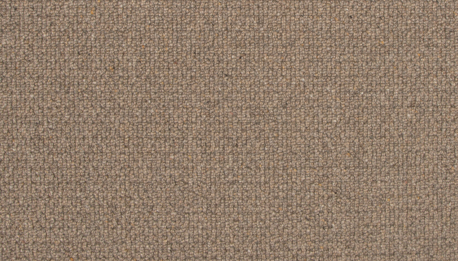 Close-up of Brixham Berber Carpet in Pioneer color, showing a soft, woolly texture and subtle grid-like weave. Durable material features small color variations throughout, adding depth to its brown surface.