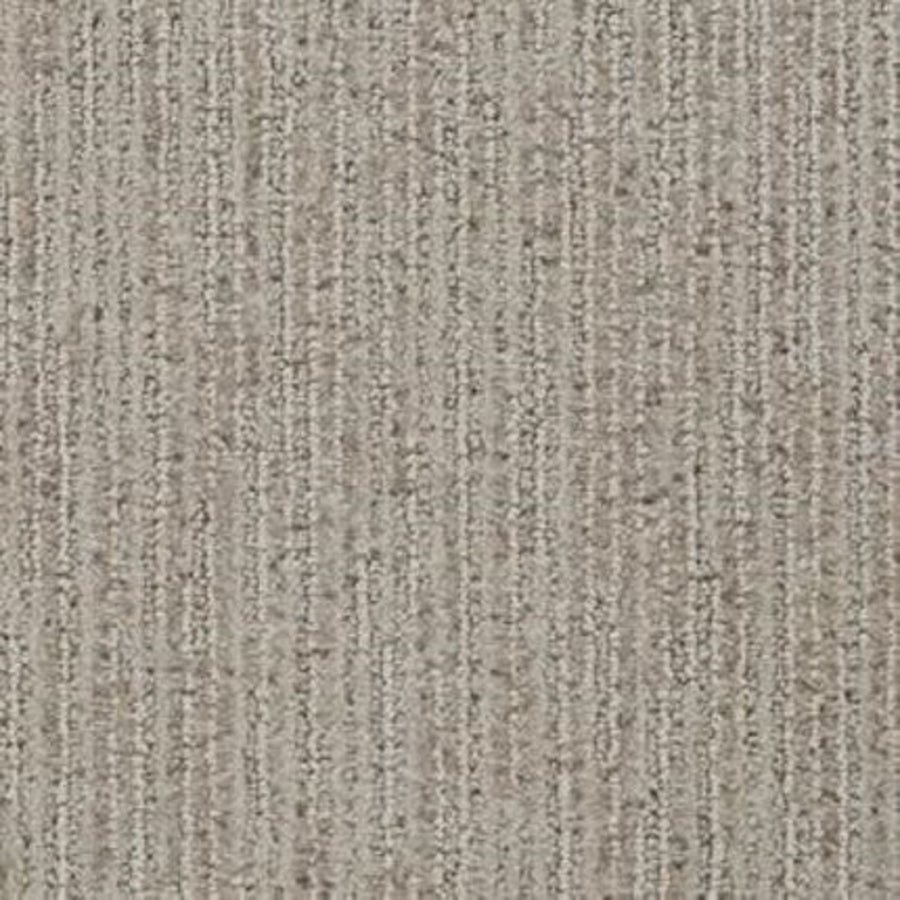 A close-up of Suspicion Family Friendly Carpet in Burnish shows its textured, stain resistant surface with vertical, slightly raised lines and a blend of fine and coarse fibers—ideal for family spaces.