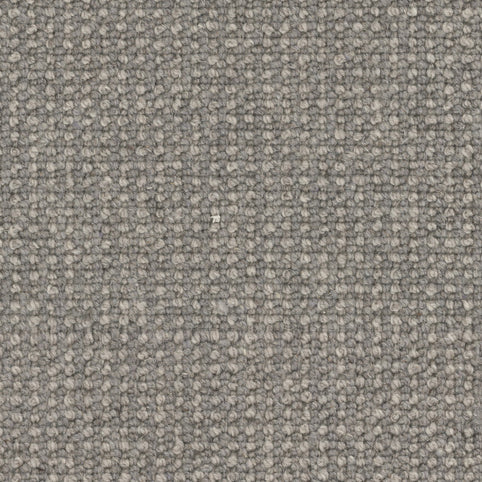 A close-up view of Andros Berber Carpet in Byzantine—a thick, hardwearing grey fabric with a looped, woven texture. Durable and ideal for upholstery or premium carpeting needs, it echoes classic Berber style.