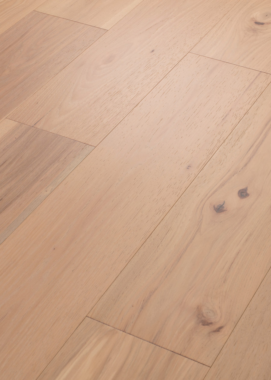 Birmingham Pecan 7 1/2" Hardwood features light tones, visible natural grain and knots, and wide planks in a staggered layout. Its smooth matte finish highlights the wood's texture and organic details for a stylish, natural look.