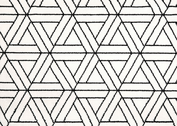 The Black & White On Trend Carpet in Pure features a modern, durable design with interlocking hexagons and triangles forming a repeating, geometric black and white pattern.