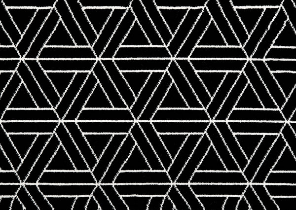 Ebony Black & White On Trend Carpet features a bold geometric pattern of interlocking white hexagons and triangles on a black background, creating a luxurious and modern statement for any space.