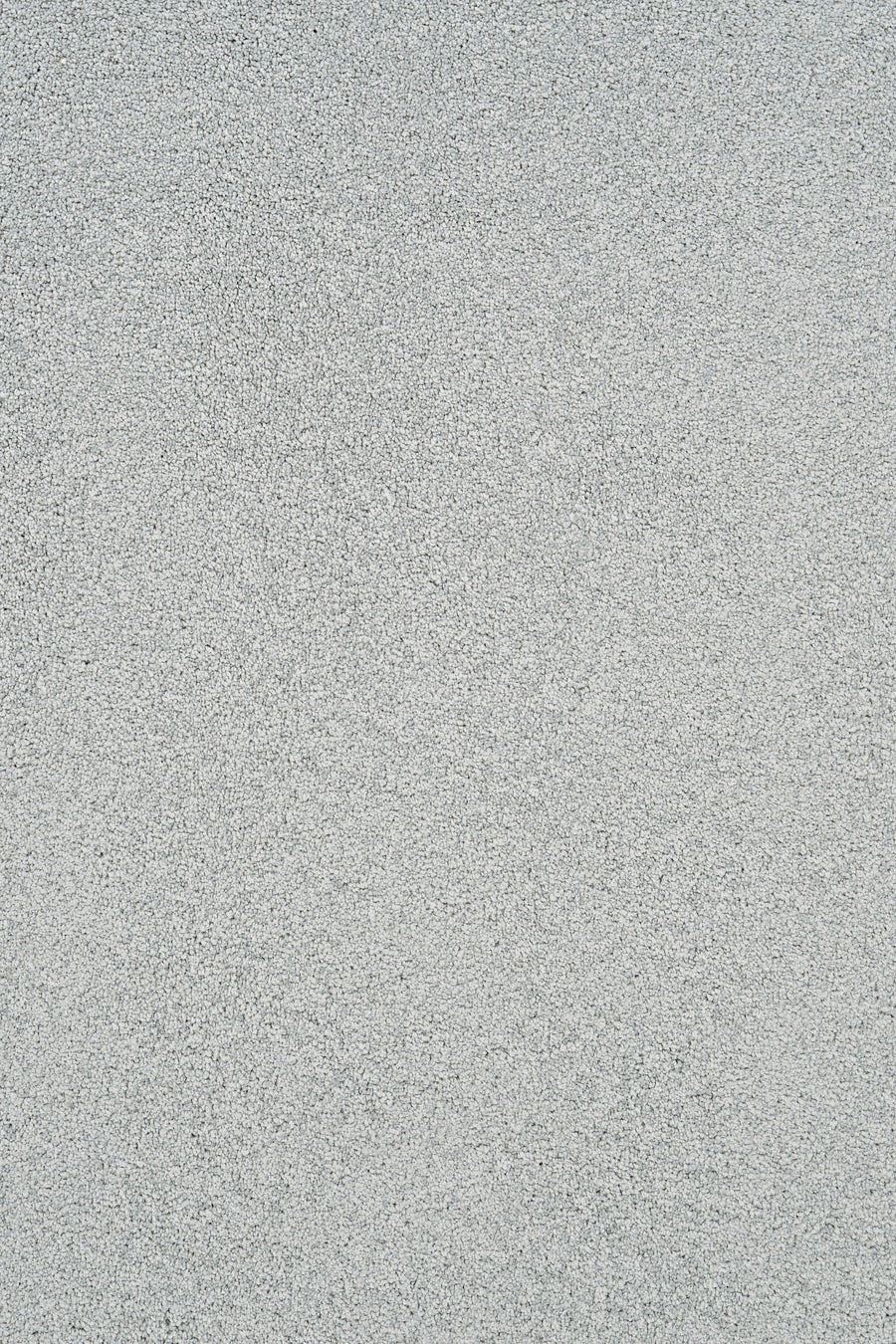 A close-up of Heavenly Family Friendly Carpet in Mineral color shows a light gray, finely speckled surface that echoes the subtle elegance and durability of luxury flooring.