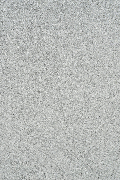 A close-up of Heavenly Family Friendly Carpet in Mineral color shows a light gray, finely speckled surface that echoes the subtle elegance and durability of luxury flooring.