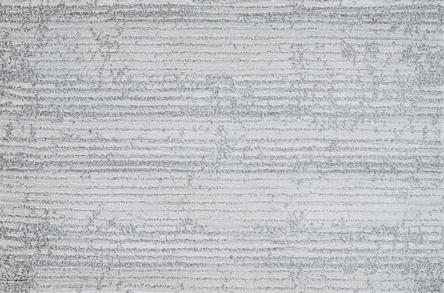 A close-up of a textured gray surface with wavy lines, similar to the refined Platinum color and pattern of Olde Chatham On Trend Carpet, celebrated for its luxury look and durable construction.