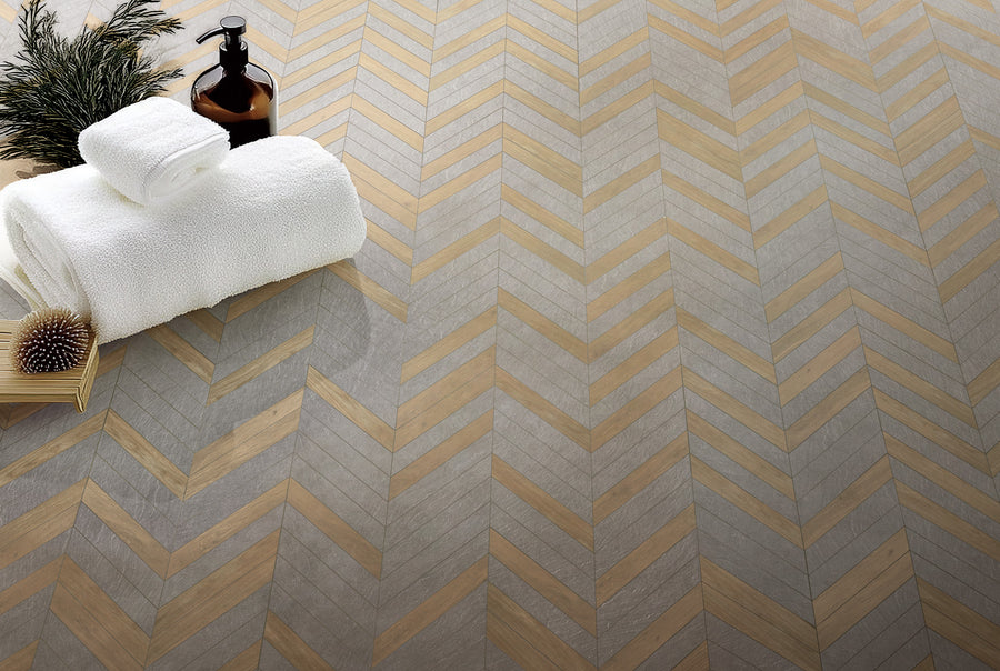 A white towels and a bottle on a chevron pattern floor.