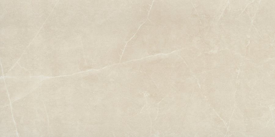 The Callie 12x24 Matte Porcelain Tile in Alabaster features a light beige surface with subtle white veining, offering a smooth, elegant look ideal for sophisticated floors or countertops.
