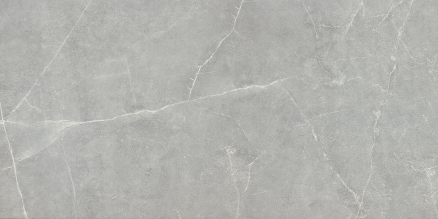 Callie 12x24 Matte Porcelain Tile in Moonlight features a light gray surface with subtle white veining and a natural texture, offering a smooth, elegant finish ideal for luxury flooring or countertops.