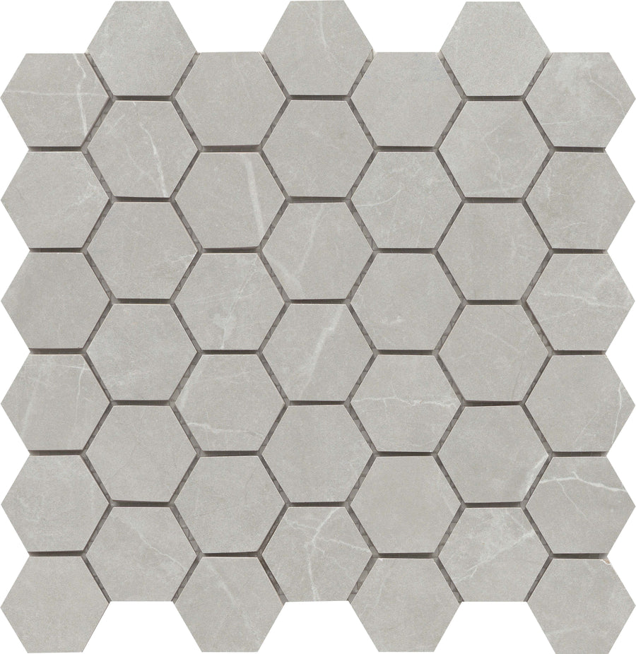 The Callie 2" Hexagon Porcelain Mosaic in Moonlight features light gray tiles with subtle white veining, arranged in a modern geometric pattern for a stylish mosaic design.