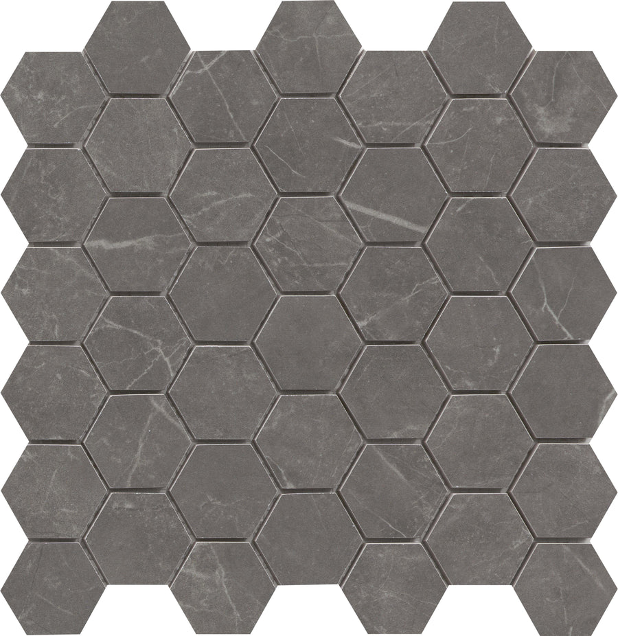 The Callie 2" Hexagon Porcelain Mosaic in Smoke features hexagonal tiles with subtle white veins, resembling marble or stone, and offers a geometric, modern luxury look.