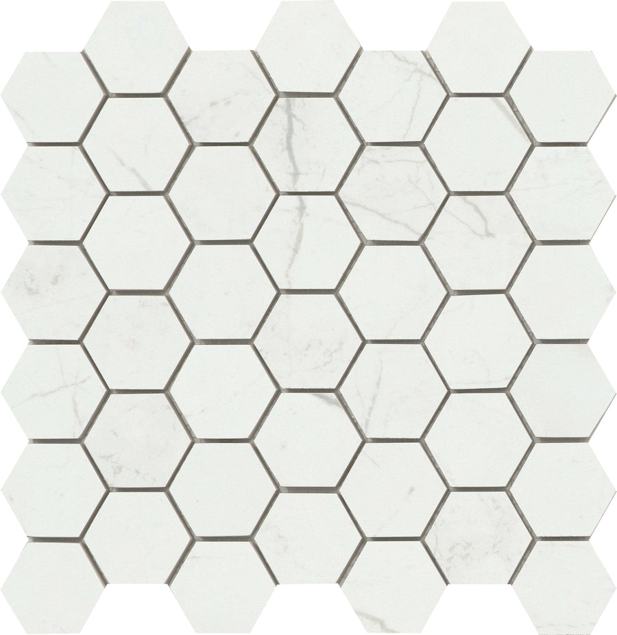 The Callie 2" Hexagon Porcelain Mosaic in Snow features a white porcelain tile with subtle gray veining, arranged in a honeycomb pattern with thin grout lines.