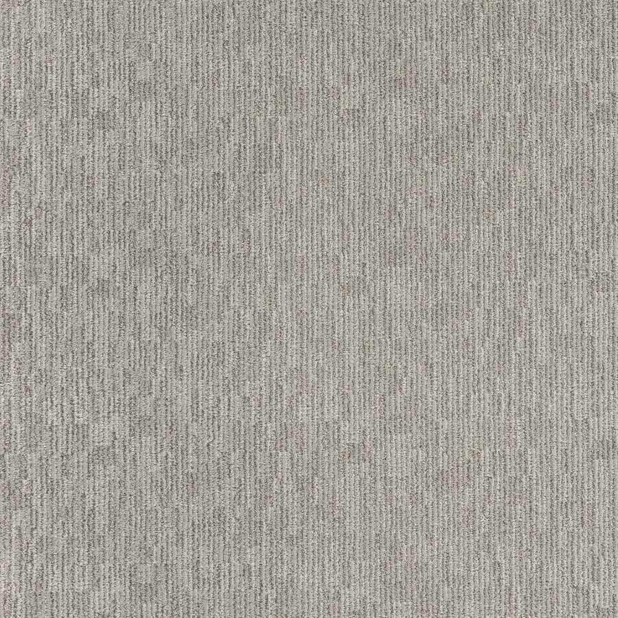 Close-up of Sneak Peak Berber Carpet in Campfire Ash shows a dense, durable pile with a soft feel. Its light gray surface features subtle, vertical linear patterns and gentle speckles for a modern, uniform look.