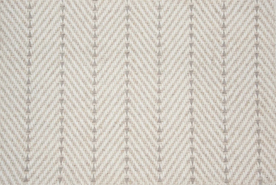 Close-up of Angola Berber Carpet in Canvas color, featuring a beige and cream herringbone pattern with V-shaped lines. The soft woven texture gives a modern look, ideal for durable flooring applications.