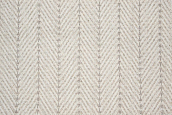 Close-up of Angola Berber Carpet in Canvas color, featuring a beige and cream herringbone pattern with V-shaped lines. The soft woven texture gives a modern look, ideal for durable flooring applications.