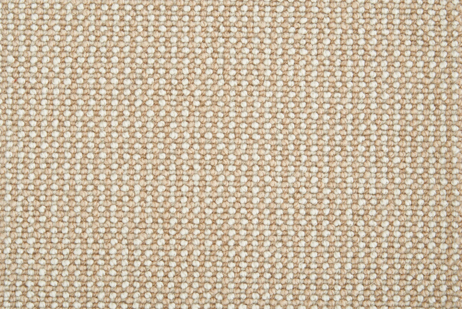 Close-up of Harper Berber Carpet in Canvas color, featuring a beige woven texture with tightly interlaced fibers in a grid pattern, emphasizing its everyday durability and comfortable feel.
