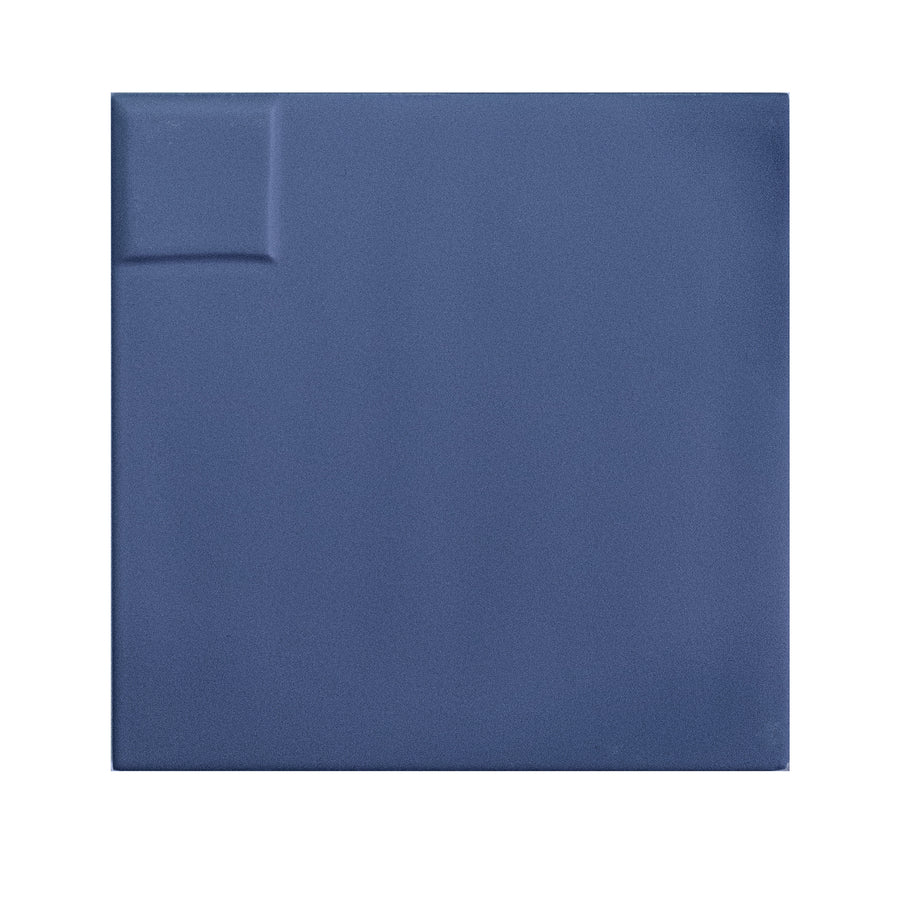 The Casbah Décor Mix 5" x 5" Ceramic Tile in indigo features a matte finish, a subtle raised rectangular detail in the top left corner, and is set against a white background.