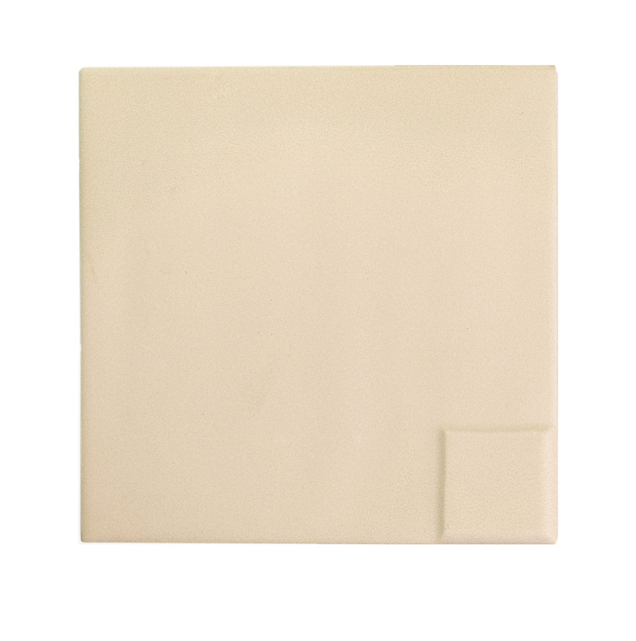 A plain, square Casbah Décor Mix 5" x 5" Ceramic Tile in Sand with a small raised square in the corner rests on a white background—an understated accent to the collection’s vibrant patterns.