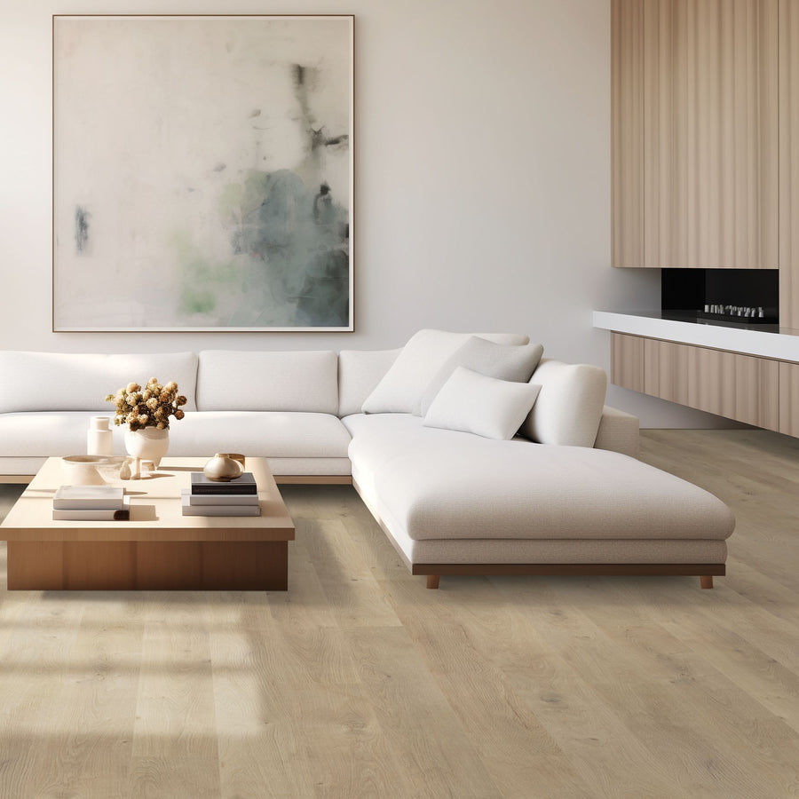 A modern living room with a light beige sectional sofa, wooden coffee table, abstract wall art, light wood floors, and minimalist cabinetry. The space feels bright, spacious, and uncluttered.