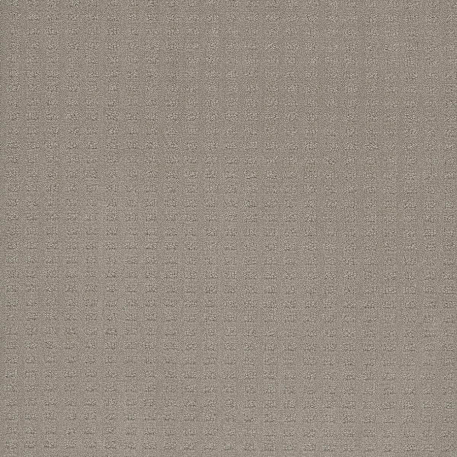 A close-up of the Caspian Berber Carpet in Arrowhead shows light brown premium fibers with a subtle checkered pattern, giving it a soft, woven texture.