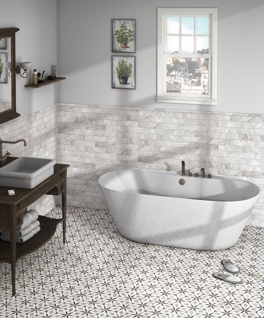 A modern bathroom with a white freestanding tub, patterned tile floor, textured white wall tiles, a wooden vanity with a vessel sink, and plants near a window letting in natural light.