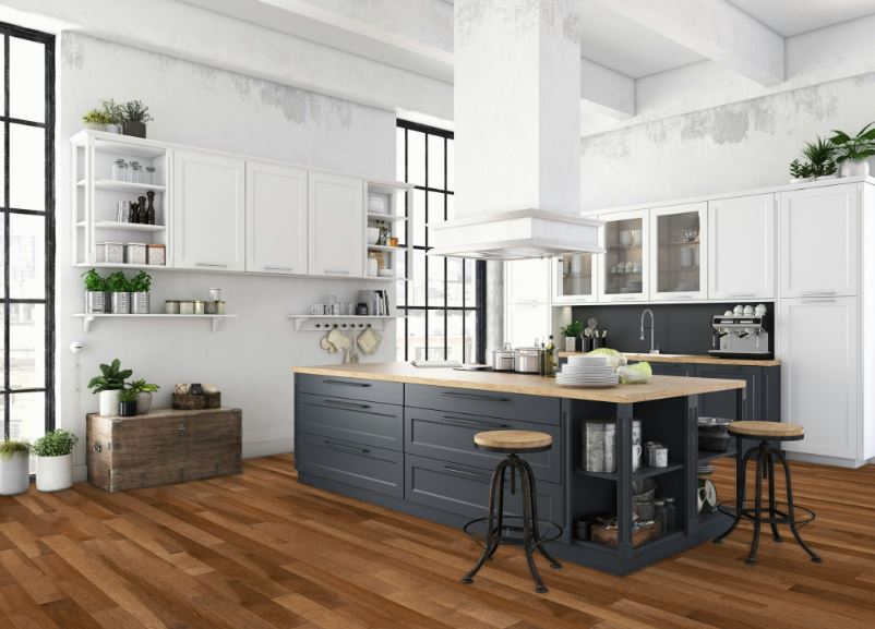 Modern kitchen with white cabinets, a large island with dark drawers and a wood countertop, two industrial-style stools, open shelves with plants, large windows, and wood flooring.