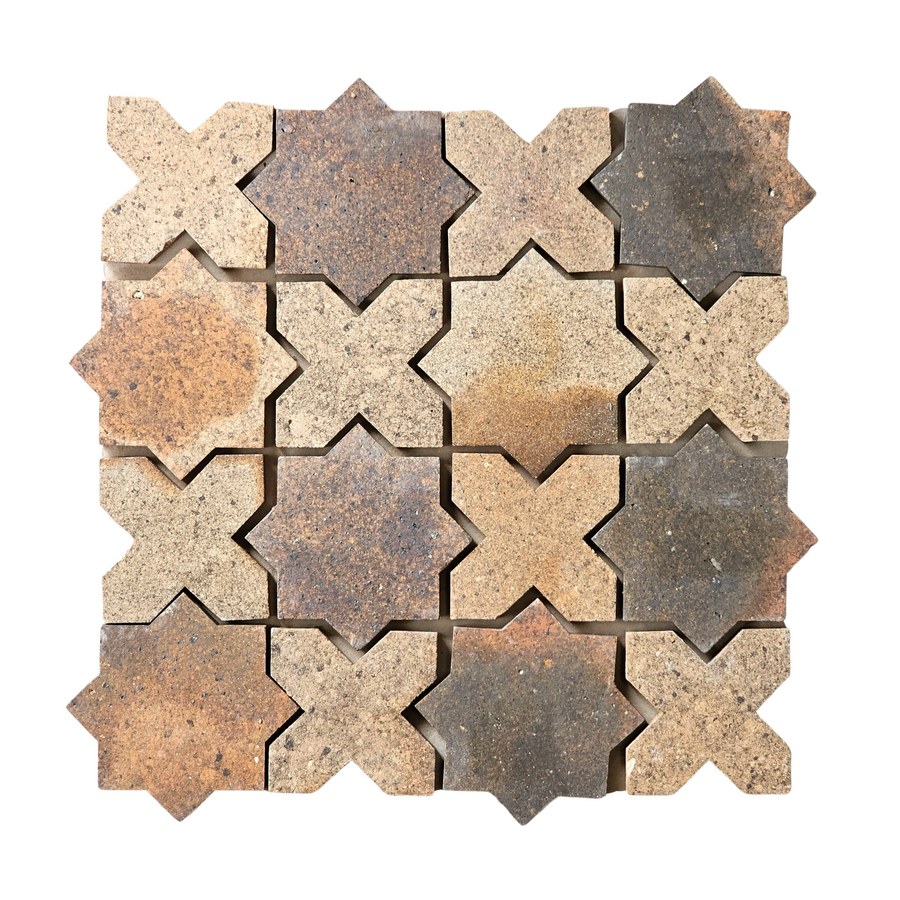 A square grid of twelve star-shaped terracotta tiles in earth tones—brown, tan, and gray—arranged on a white background, echoing the look of Atelier Clay XOXO Mosaic Natural Stone.