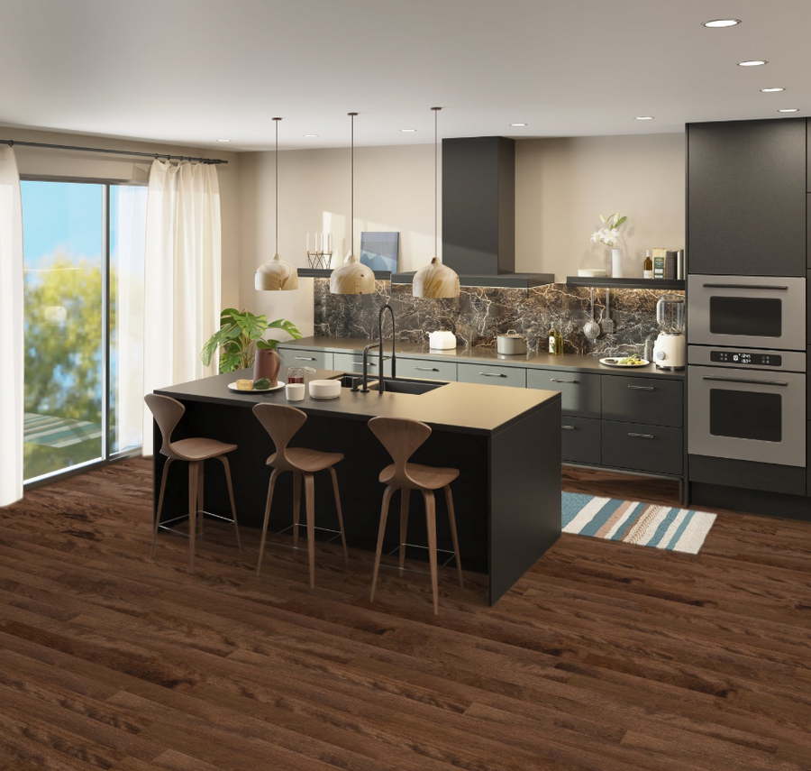 Modern kitchen with dark cabinets, marble backsplash, and a central island with three wooden barstools. Pendant lights hang above, and sunlight streams in from large sliding glass doors with white curtains.