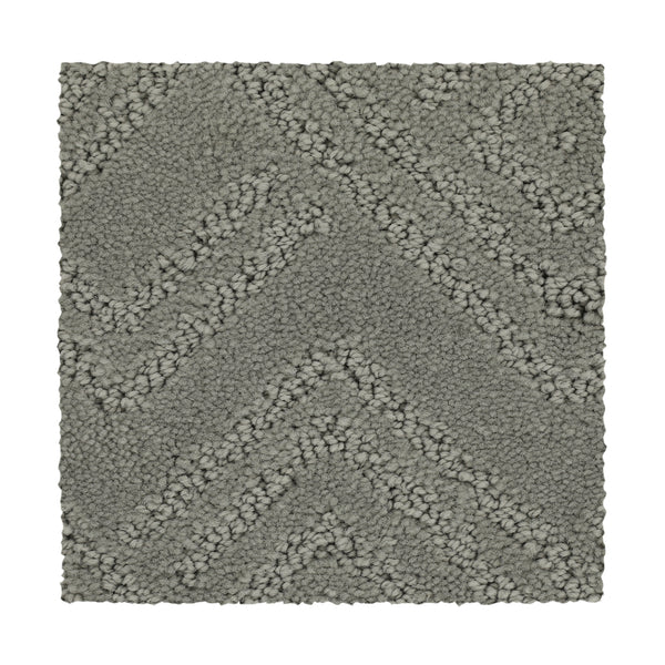 A rectangular swatch of Classic Frame Family Friendly Carpet in Steambath, showcasing a gray, durable chevron pattern with alternating rows of tightly and loosely woven fibers.
