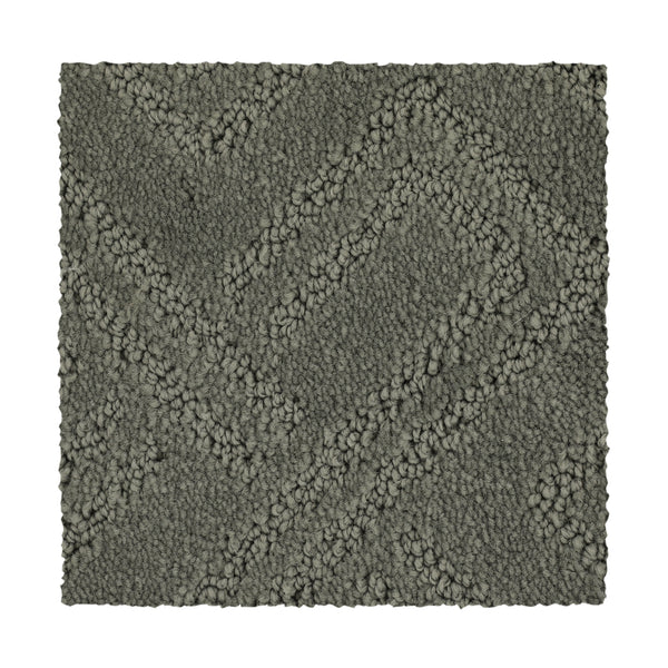 A square swatch of Classic Frame Family Friendly Carpet in Retreat. This dark gray luxury carpet features a raised zigzag pattern and a mix of looped and cut fibers, creating a subtle geometric design with clean edges for sophisticated appeal.