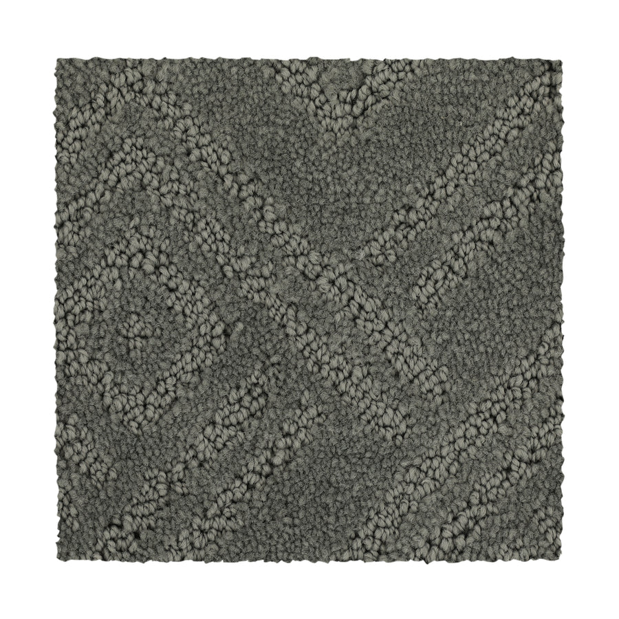 Classic Frame Family Friendly Carpet in Titan is a rectangular, dark gray swatch with a raised geometric diamond and diagonal pattern. Its surface combines looped and cut fibers for a plush, textured look.