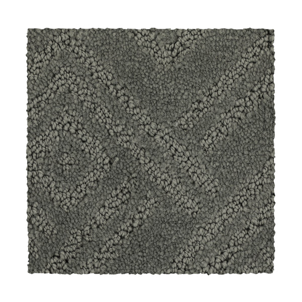 Classic Frame Family Friendly Carpet in Titan is a rectangular, dark gray swatch with a raised geometric diamond and diagonal pattern. Its surface combines looped and cut fibers for a plush, textured look.