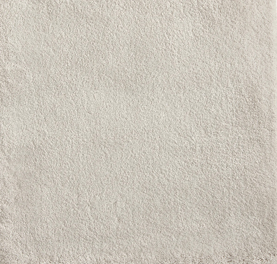A close-up of the Cha Cha On Trend Carpet in Cloud showcases its soft, light beige terry texture and subtly uneven edges—perfect for contemporary spaces or as an accent in high-traffic areas.