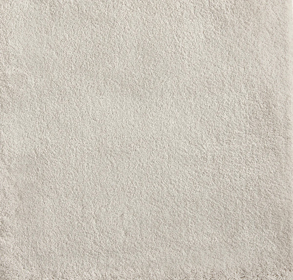 A close-up of the Cha Cha On Trend Carpet in Cloud showcases its soft, light beige terry texture and subtly uneven edges—perfect for contemporary spaces or as an accent in high-traffic areas.