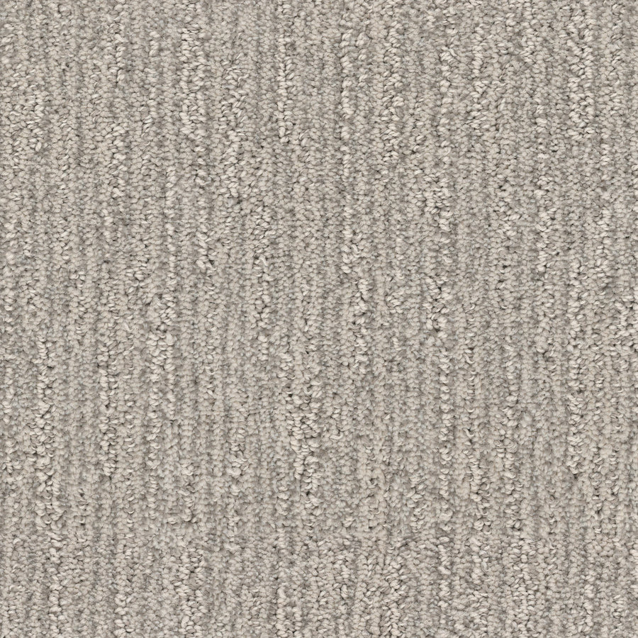 Close-up of Contentment Pet Friendly Carpet in gray, featuring a looped fiber pattern with vertical lines. The stain-resistant, soft surface appears even and neutral throughout the image.