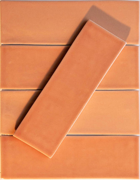 Six Noir Crackle 2.5x8 Ceramic Tiles in Coral-line are arranged in a grid, with one tile placed diagonally at the center, its subtle crackled finish creating a standout visual effect.