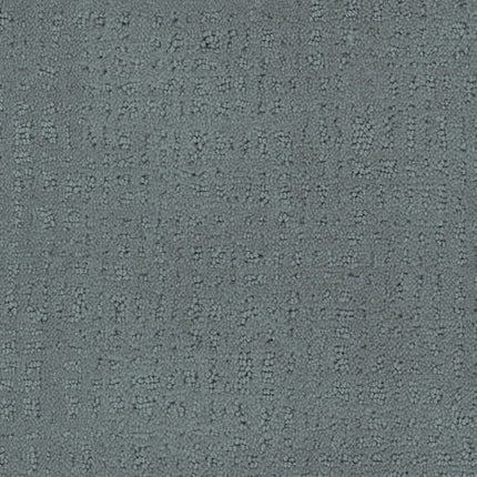 Close-up of Homage Berber Carpet in Cortina—features a textured gray surface with a subtle, irregular dotted and dashed pattern, offering a slightly raised, tactile feel that's ideal for high-traffic spaces.
