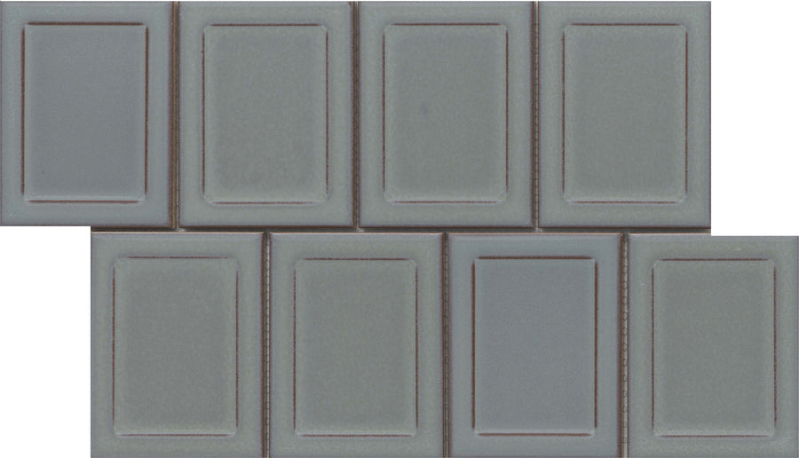 Seven Marco and Polo 4x5 Glossy Porcelain Tiles in Marco Gray are arranged in two staggered rows, creating a brick-like pattern. Each tile has a raised rectangular border, giving a refined, designer-inspired framed appearance.