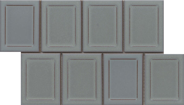 Seven Marco and Polo 4x5 Glossy Porcelain Tiles in Marco Gray are arranged in two staggered rows, creating a brick-like pattern. Each tile has a raised rectangular border, giving a refined, designer-inspired framed appearance.