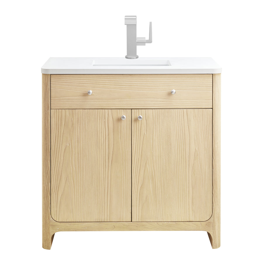 A light wood bathroom vanity with two cabinet doors, a white drawer above them, a white countertop, and a modern silver faucet.