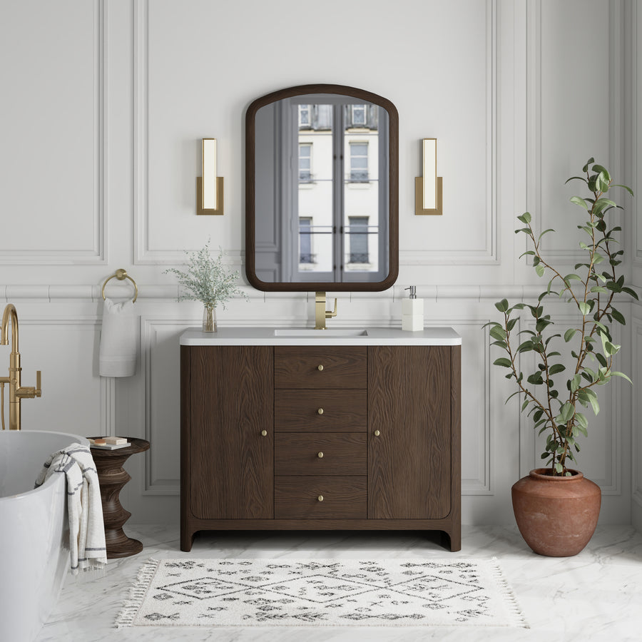 Elegant bathroom with the Gracyn 48" Vanity, gold fixtures, a large mirror, wall sconces, a potted plant, and a freestanding tub. White walls and floors highlight the transitional design for a bright, sophisticated look.