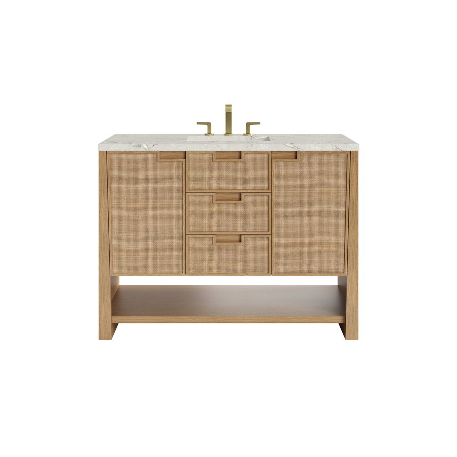 A wooden bathroom vanity with a marble countertop, brass faucet, three center drawers, two side cabinets, and an open lower shelf, set against a white background.