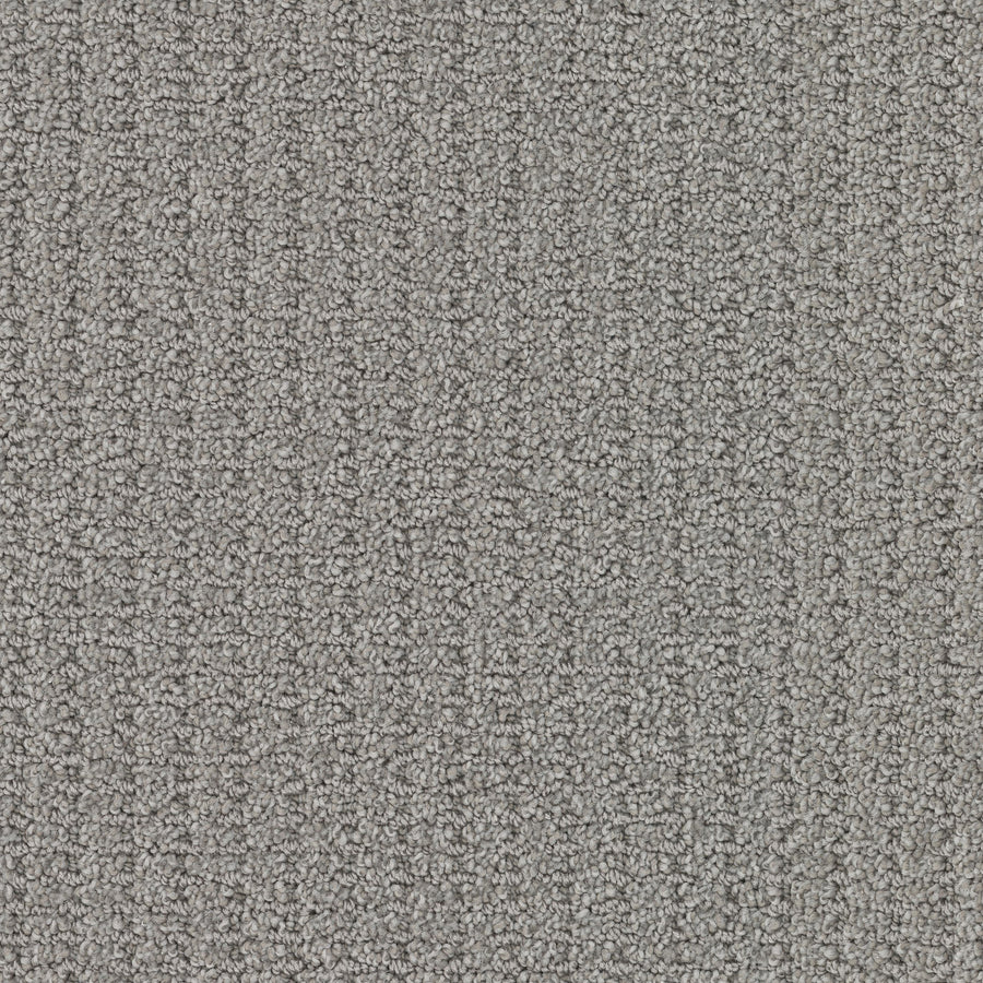 Close-up view of Defined Family Friendly Carpet in gray, featuring a loop-pile, textured surface. Its dense, tightly woven fibers provide soft luxury, durability, and a uniform appearance—perfect for families.