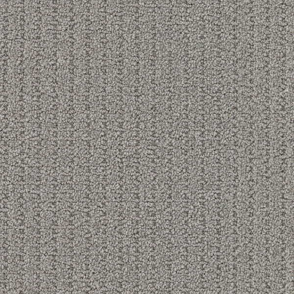Close-up view of Defined Family Friendly Carpet in gray, featuring a loop-pile, textured surface. Its dense, tightly woven fibers provide soft luxury, durability, and a uniform appearance—perfect for families.