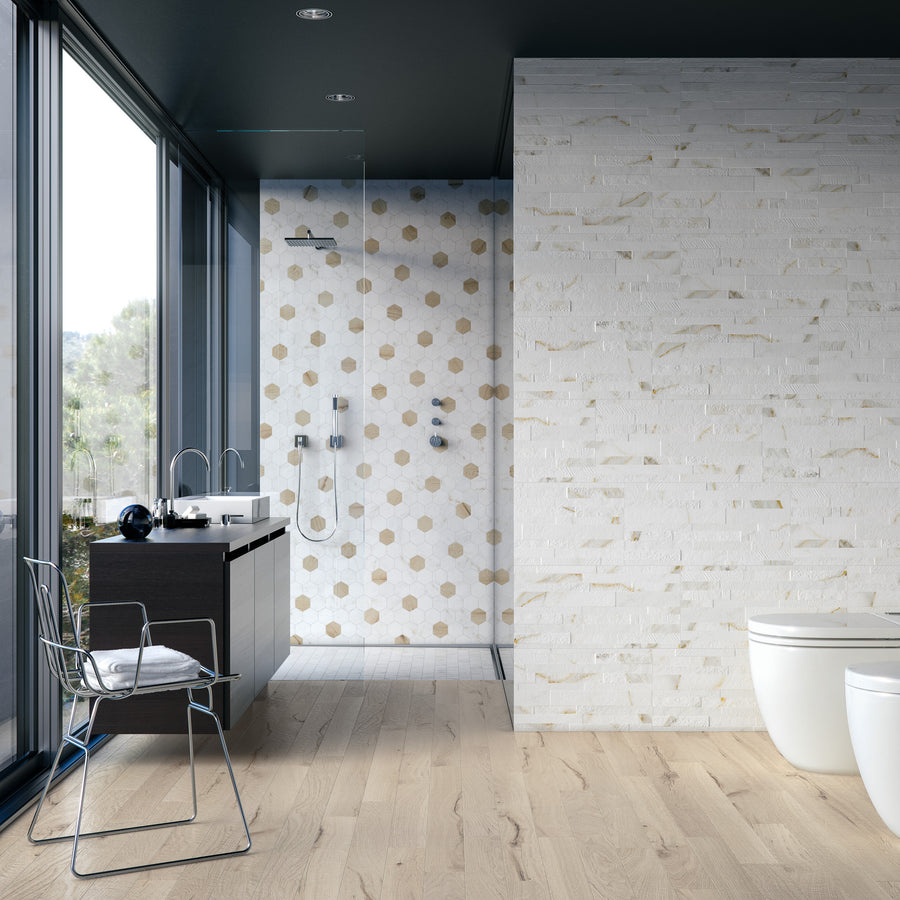 Modern bathroom with large windows, wooden floor, a dark vanity, metal chair, open shower with polka dot tiles, and white brick accent wall. Natural light fills the space.